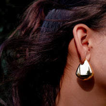 Load image into Gallery viewer, Model wearing Teuila Fatupaito Mirror Luxe Studs, showcasing how the gold plated earrings reflect light