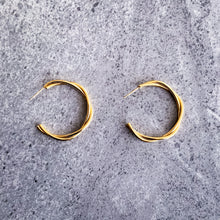 Load image into Gallery viewer, Teuila Fatupaito Twisted Hoops in 18K gold PVD plated stainless steel, front view showing unique twisted design