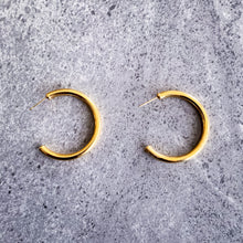Load image into Gallery viewer, Teuila Fatupaito Hollow C-Shaped Hoops in 18K gold PVD plated stainless steel, front view showing elegant curved design