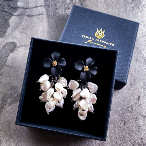 Teuila Fatupaito Forget Me Not Pearls, front view showing elegant baroque freshwater pearls with rubber coated steel studs showing packaging. 